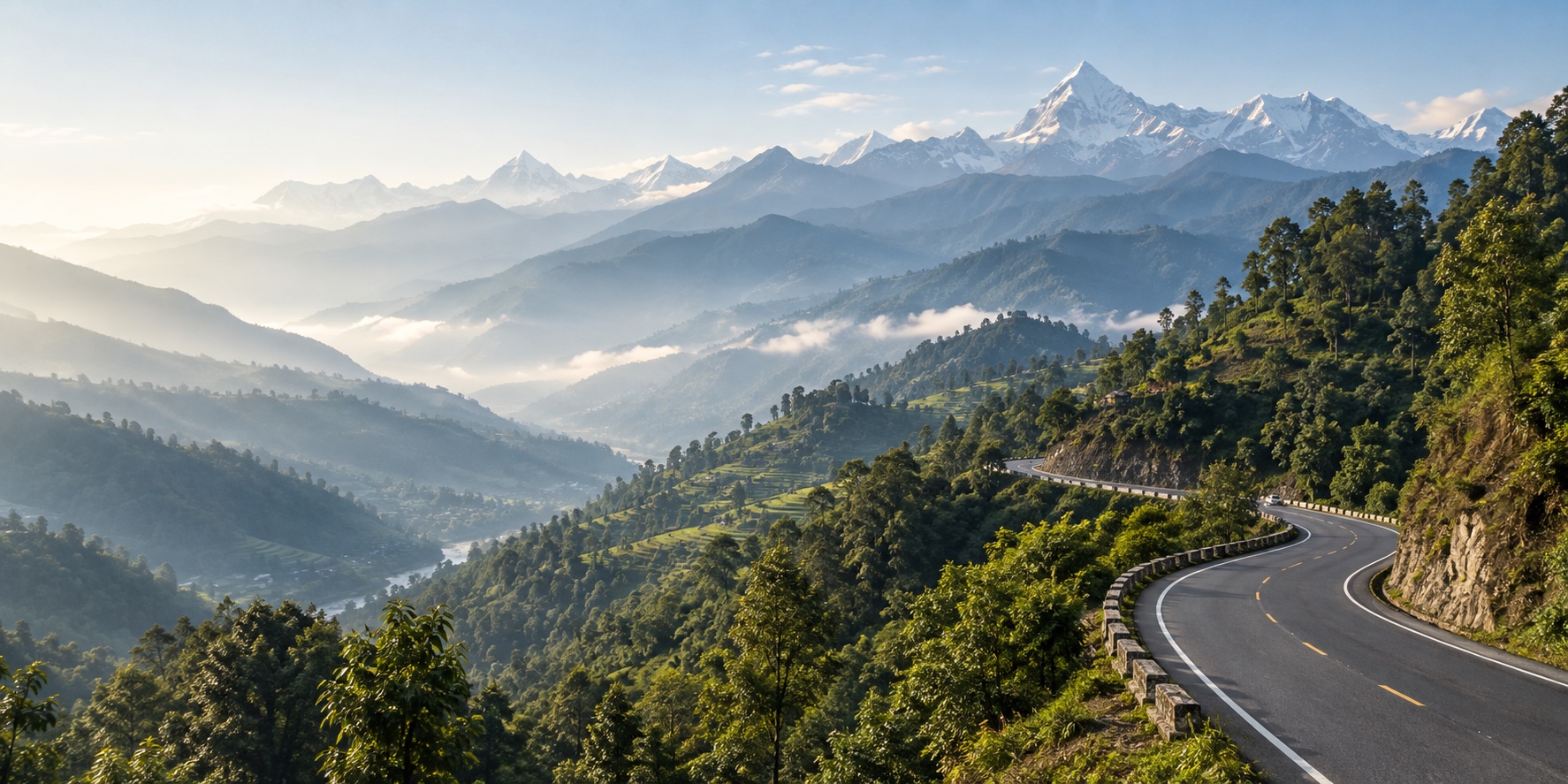 A mountain road winding through forested hills towards the snow-capped Himalaya
